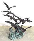 cast bronze herons on rock statue 