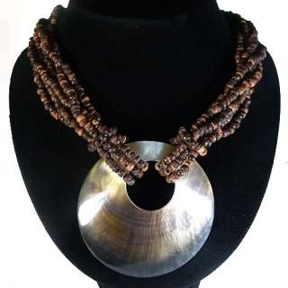   beach style wood necklace with a huge round shell that complements