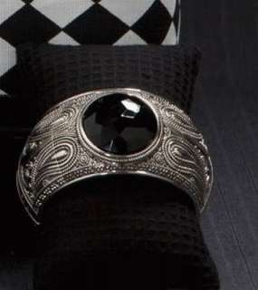 Silver toned metal cuff bracelet with hinge. Simulated large black 