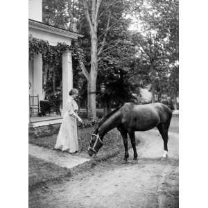 Helen Keller, full length portrait standing on lawn holding reins to a 