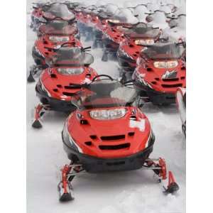  A Large Group of Snowmobiles Sit Waiting for Action 